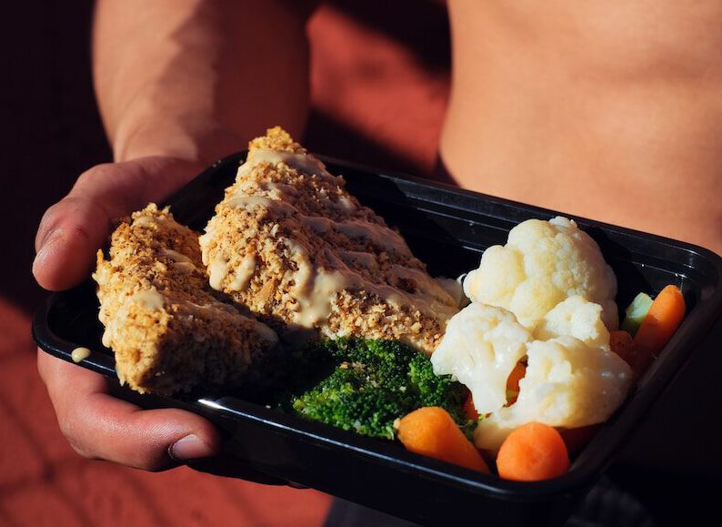 person holding cooked food on black tray